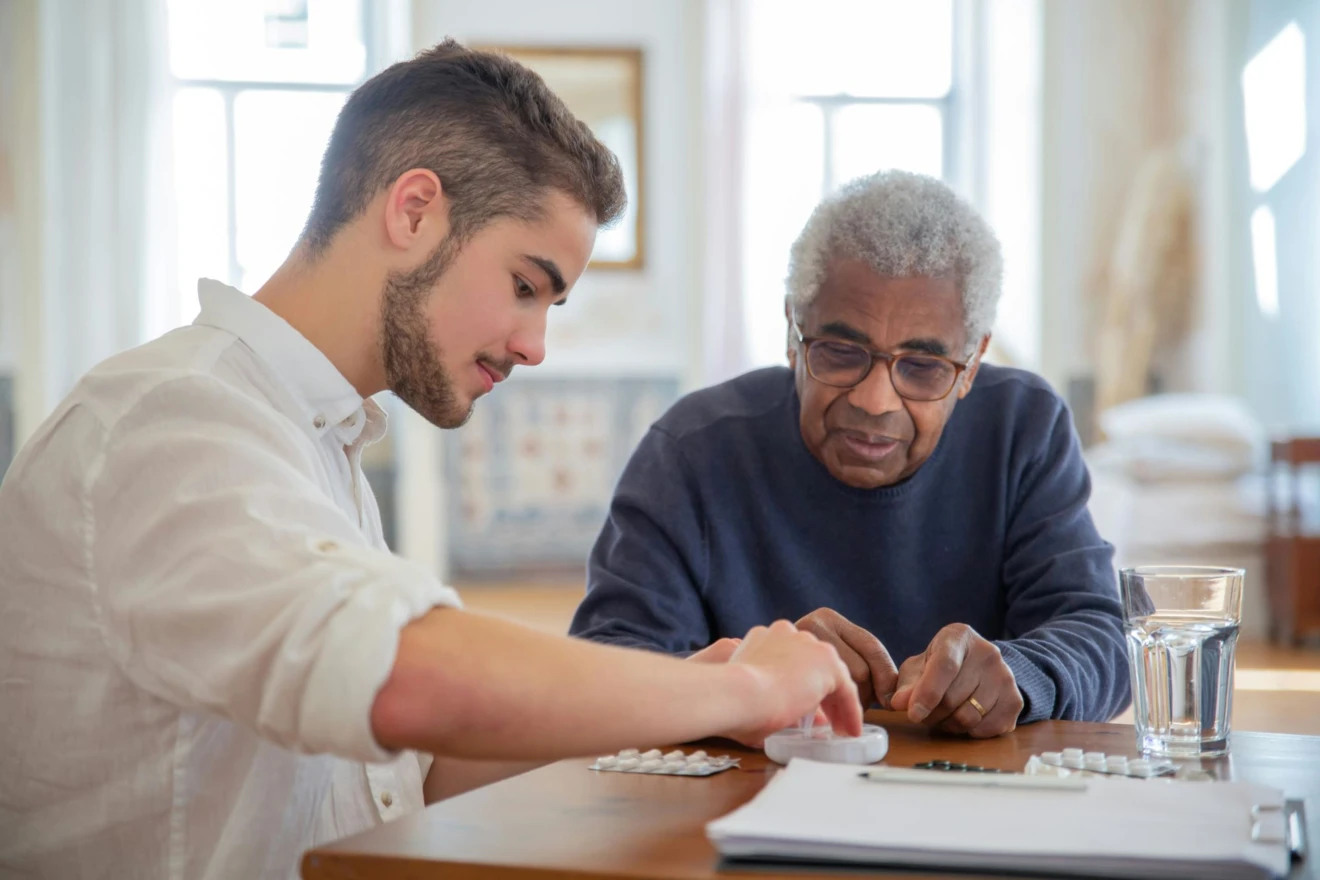 Ältere Person wird im Pflegeheim von einer pflegenden Person betreut. Sie füllen gemeinsam Tabletten in eine tragbare Tablettenbox.

Foto: Kampus Production